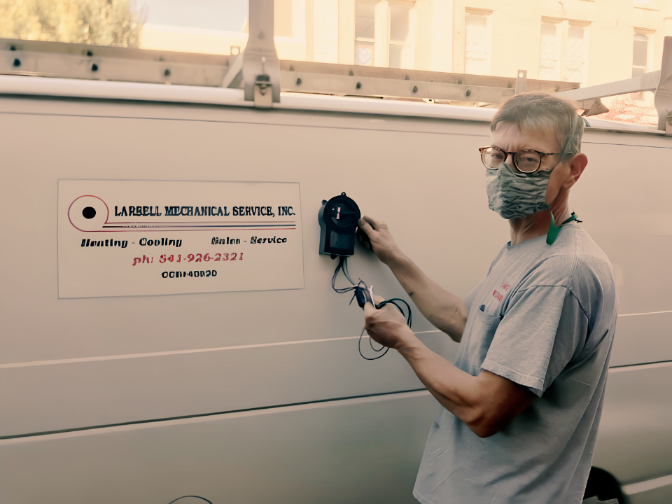 R. Dennis Larsell with the original Larsell Mechanical van, carrying the family standard forward.